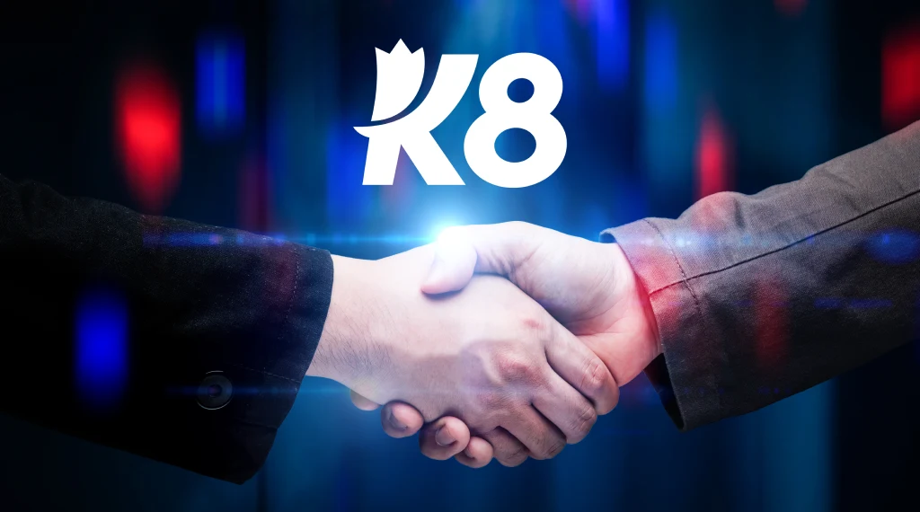 Handshake with the K8 logo in the background, symbolizing trust and partnership in selecting a reliable crypto casino.