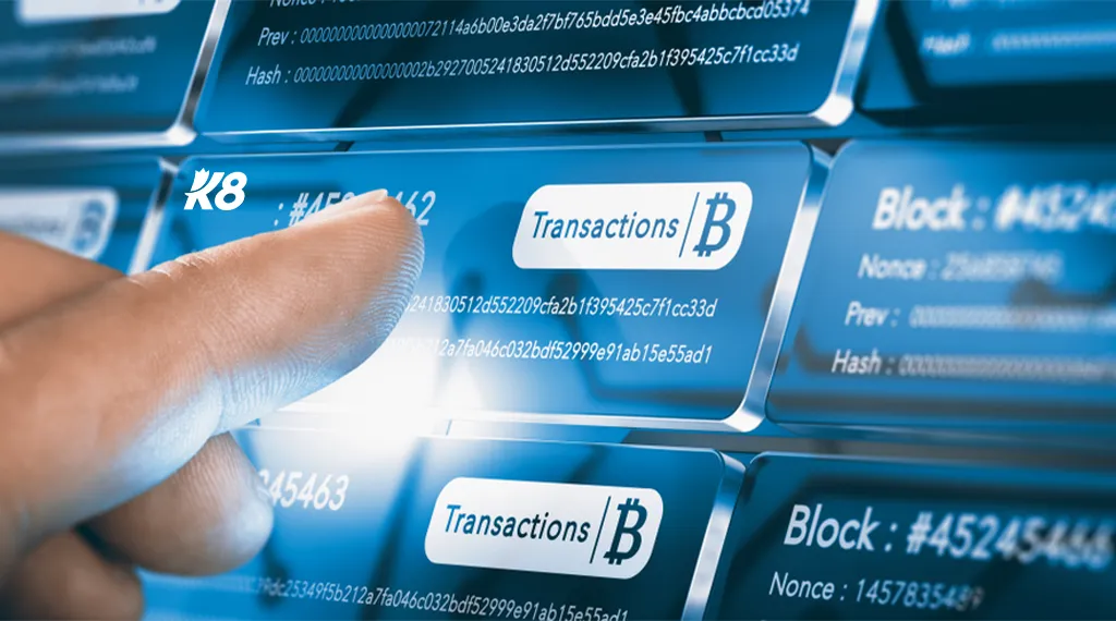 A finger selecting a Bitcoin transaction on a digital blockchain interface with K8 logo.