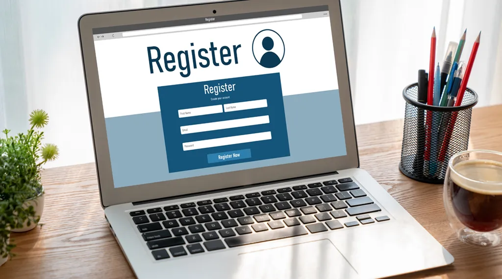 Laptop showing a registration form with fields for first name, last name, email, and password.