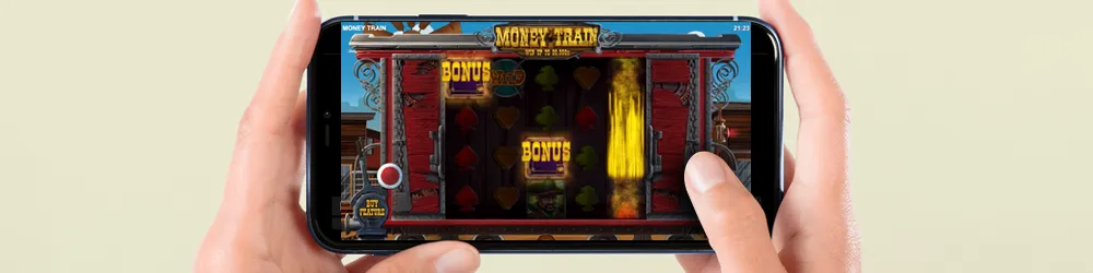 A person holding a smartphone displaying the Money Train game on its screen.